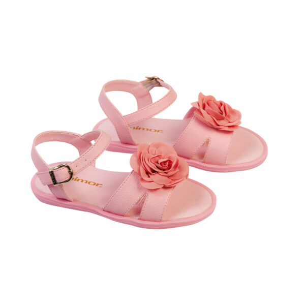 Son sandalias abiertas de color rosa intenso, diseñadas para niñas. Están adornadas con una flor grande en la parte superior y parecen estar hechas de un material suave y flexible, posiblemente goma o plástico.